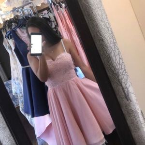 A light pink cocktail dress with a lace up back.